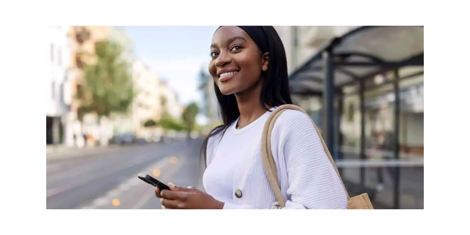 a smiling girl is looking at her phone